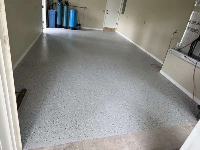 The same garage floor with a gray speckled coating, and the same tanks along the left wall.