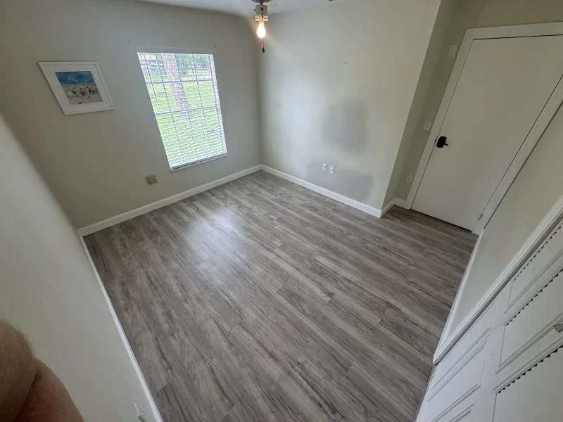 The same room with new gray wood-look plank flooring installed.